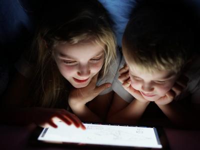 Siblings on tablet at night time